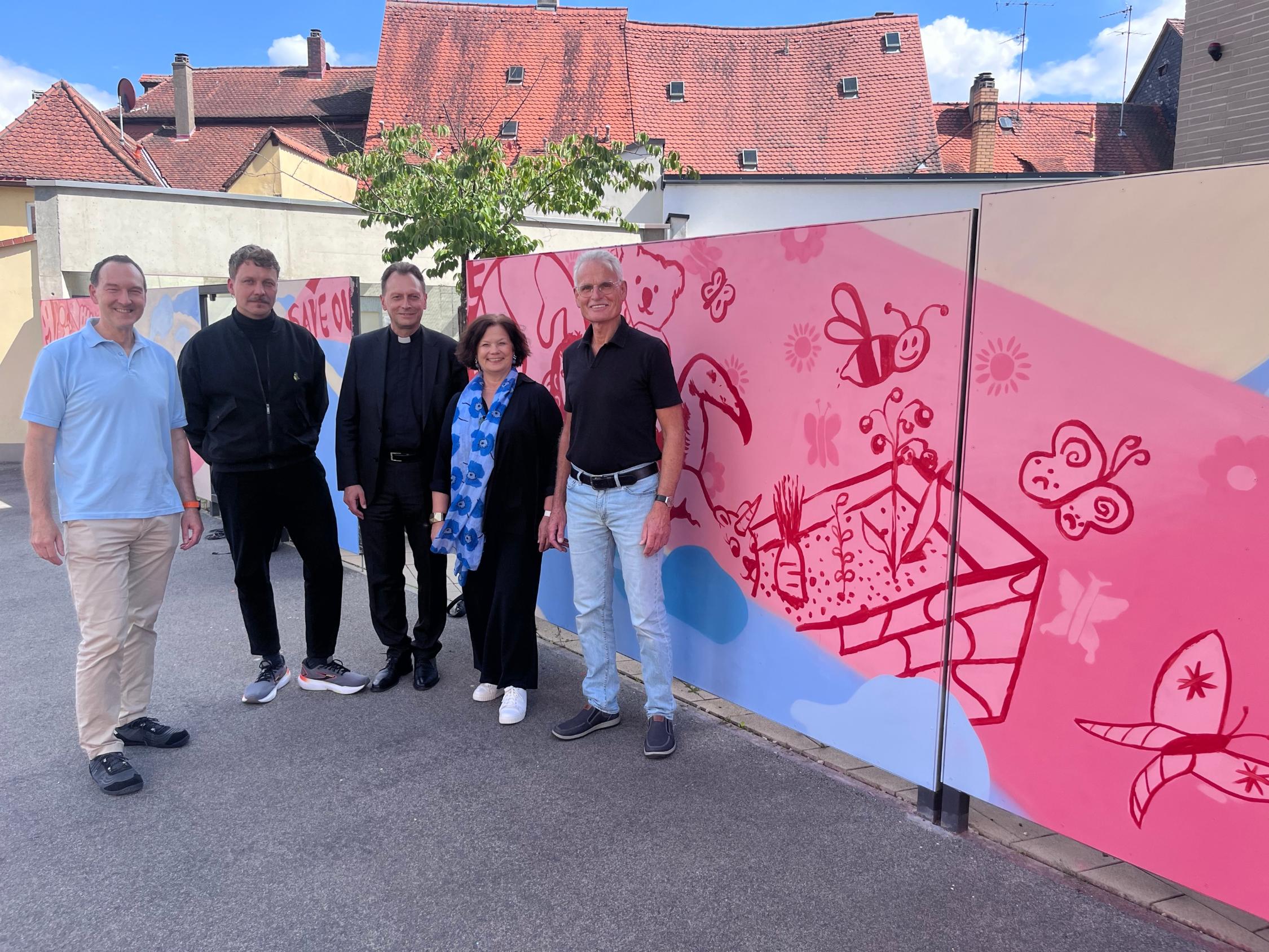 Erzbischof Herwig Gössl (Mitte) segnete das neue Graffiti am Tor der Maria-Ward-Schule. Darüber freuten sich Schulleiter Stephan Reheuser (von links) Künstler Sebastian Magnus, Schulleiterin Barbara Hauck und Hans-Dieter Franke, der ehemalige Leiter der Hauptabteilung Schule im Erzbistum.     Foto: Benjamin Kemmer